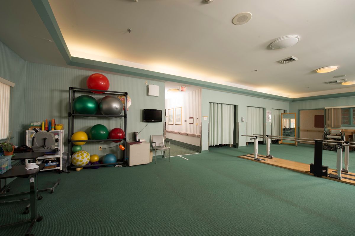 A spacious gym featuring racks of medicine balls and exercise equipment.