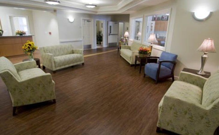 A spacious living room with multiple sofas and chairs on a hardwood floor.