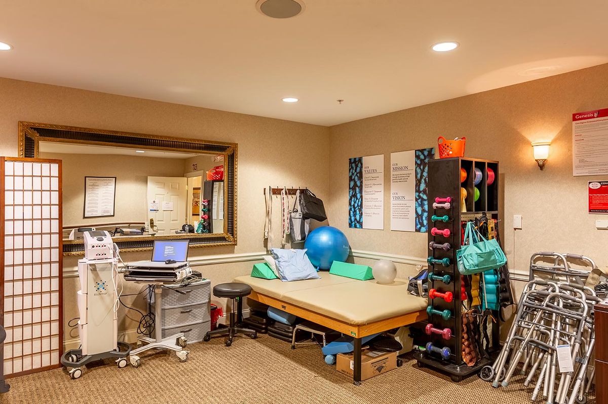 A well-equipped physical therapy room featuring a treatment table, gym ball, and various exercise equipment.