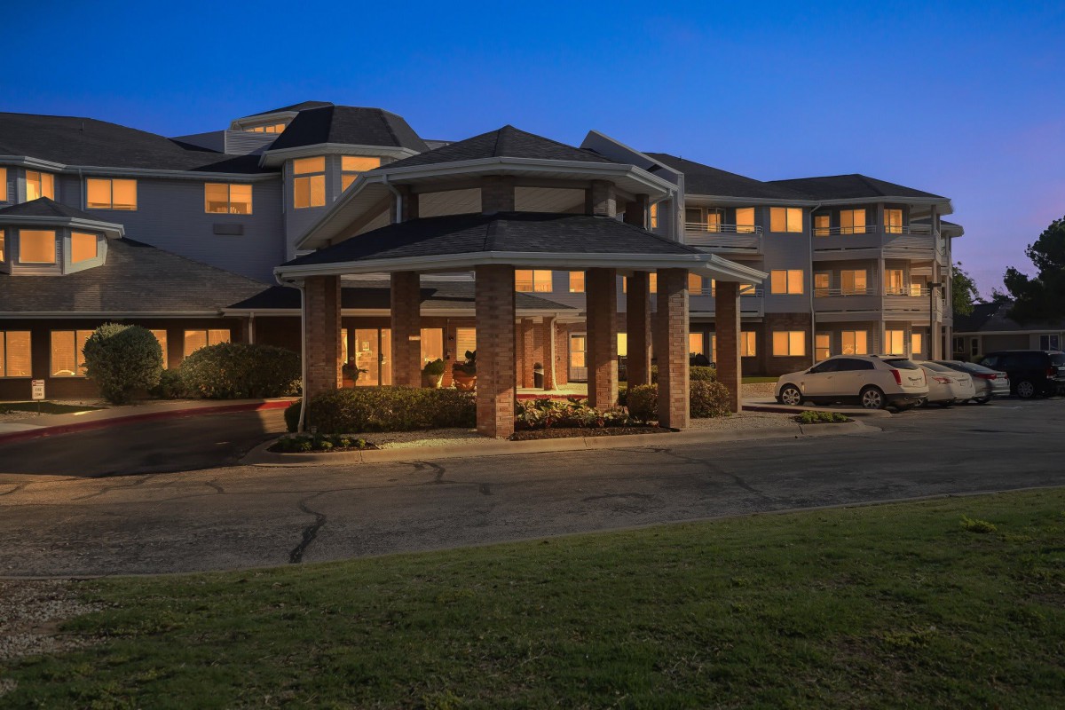 A well-lit hotel exterior at night, showcasing its architectural design.
