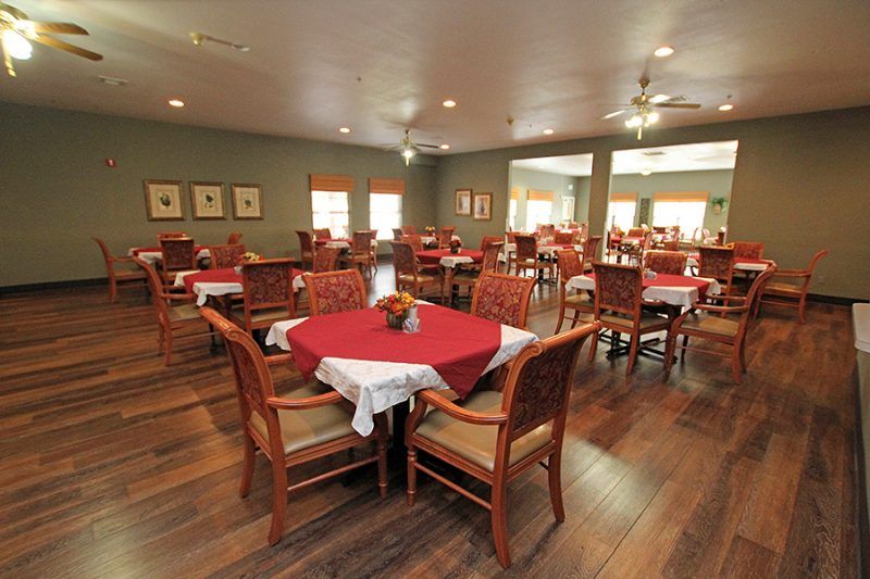 An empty restaurant dining area with neatly arranged tables and chairs.