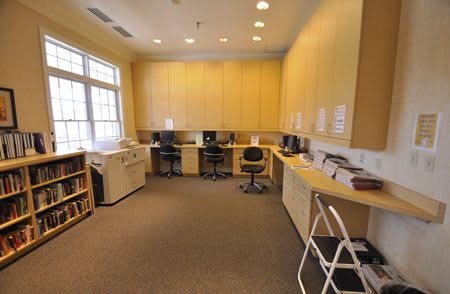 A small office space with desks, computers, and a printer.