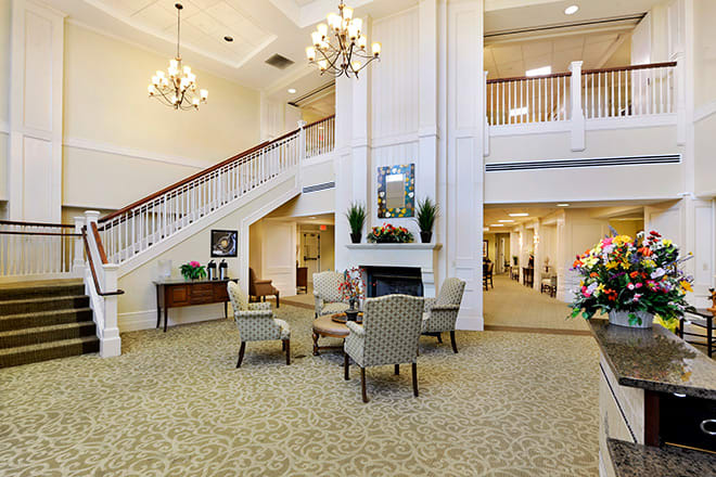 A spacious and elegantly decorated lobby with comfortable seating and a grand staircase.