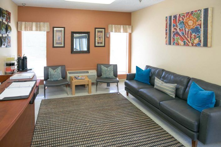 A well-lit living room with a sofa, chairs, and decorative elements.