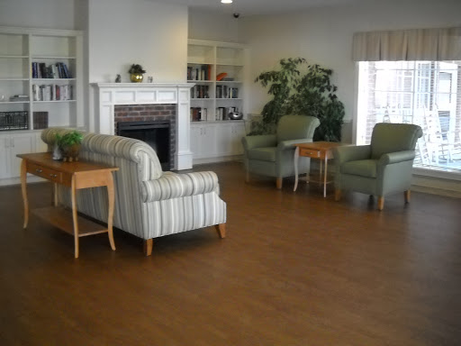 A cozy living room featuring comfortable seating, a fireplace, bookshelves, and decorative plants.