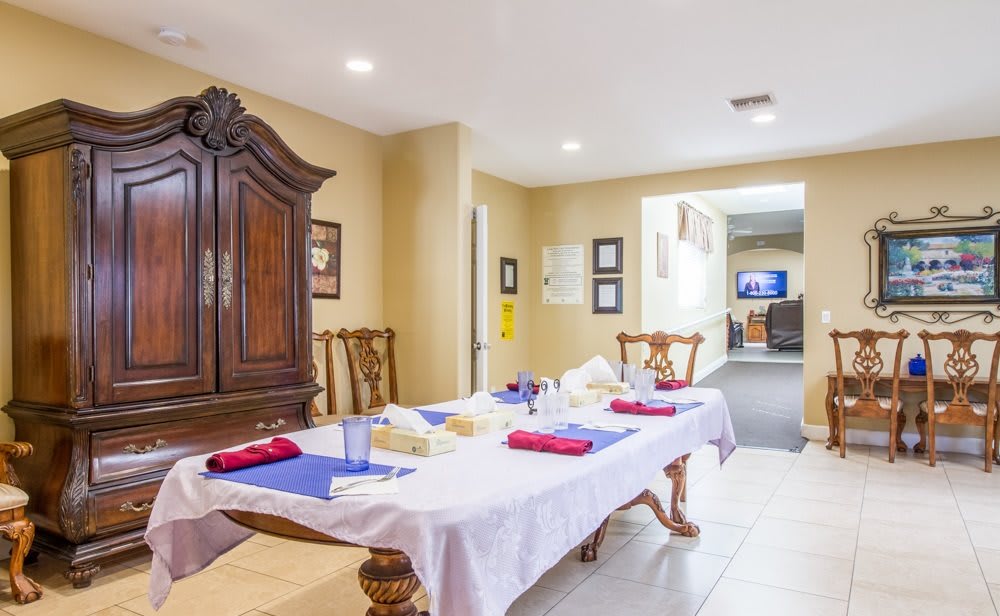 A dining room with a table set for a meal, featuring wooden furniture and elegant decor.