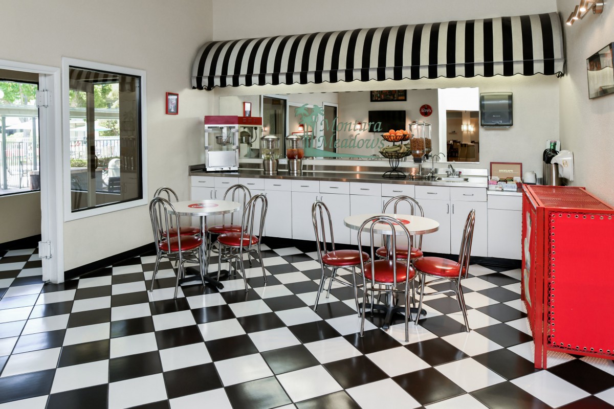 A retro diner with checkered floors and red chairs.