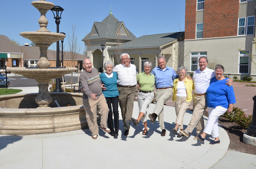 A joyful gathering of friends enjoying a sunny day by the fountain.