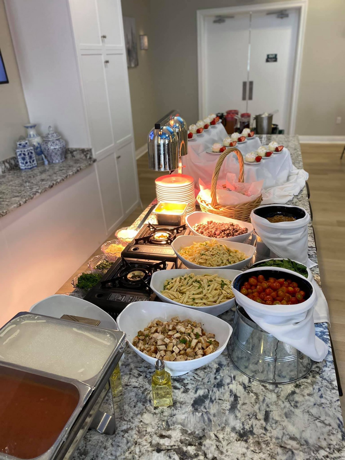 A beautifully arranged buffet featuring pasta and various toppings in a self-serve setting.