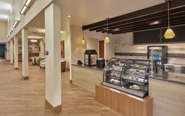 Modern cafe interior with a dessert display and seating area.