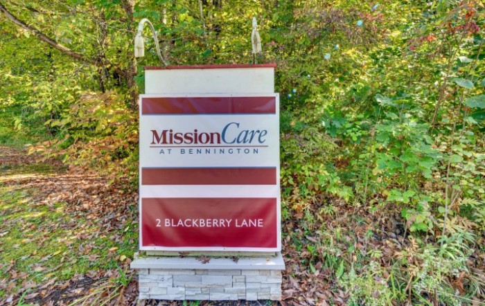 A sign for MissionCare at Blackberry Lane, set amidst greenery.