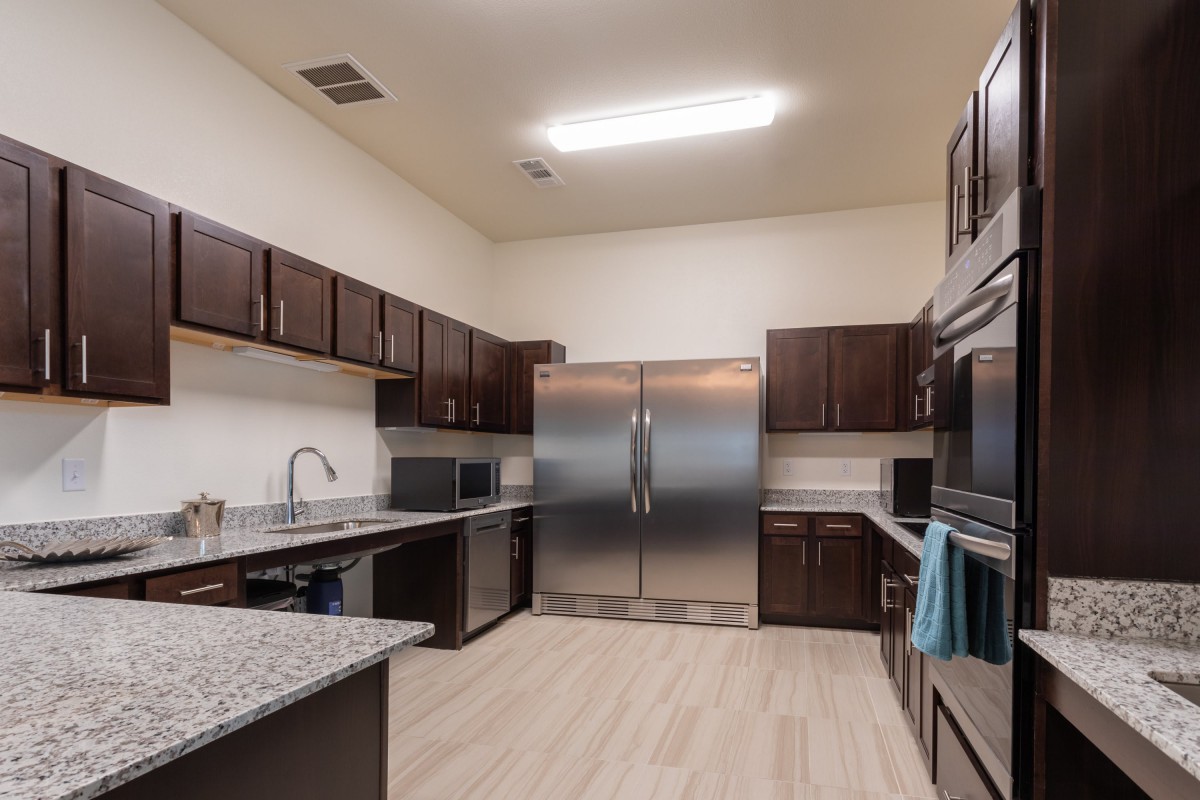 A modern kitchen with stainless steel appliances and dark wood cabinets.