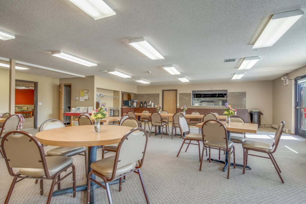 A spacious dining area with multiple tables and chairs, suitable for community gatherings.