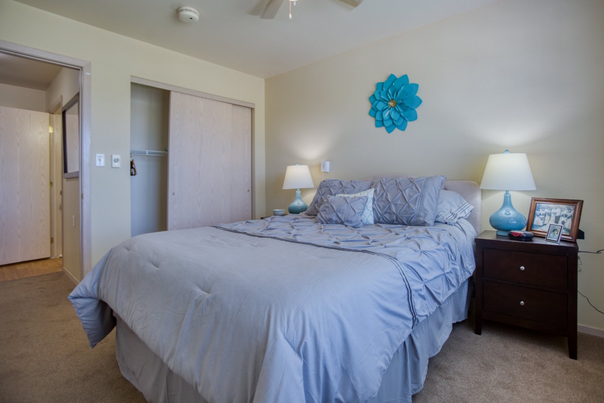 A cozy bedroom with blue-themed decor and neatly arranged furnishings.