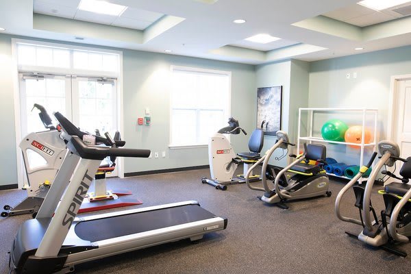 A well-equipped gym featuring a treadmill, stationary bike, and other fitness equipment.