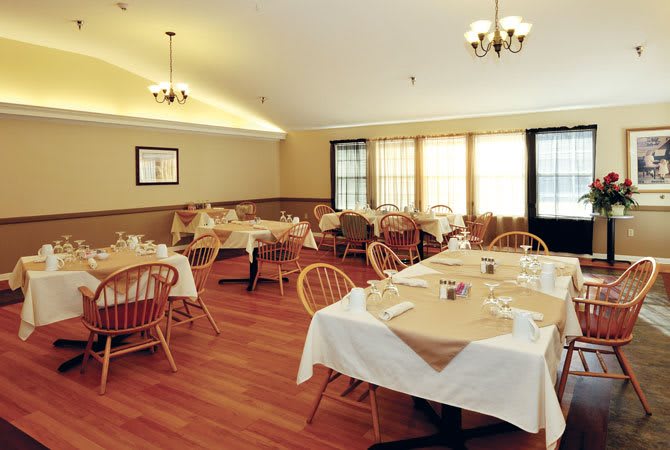 An empty restaurant dining area with neatly arranged tables and chairs.