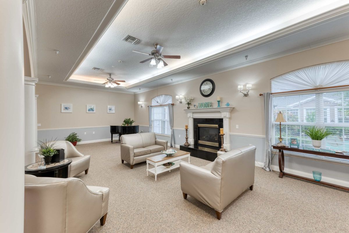 A cozy living room with neutral-toned furniture, a central fireplace, and elegant lighting.