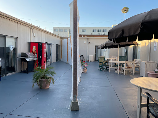 An outdoor patio area featuring a grill, seating arrangements, and a vending machine.