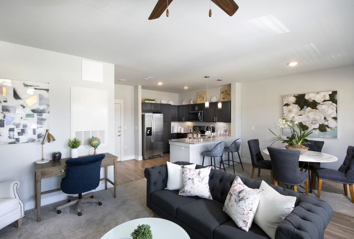 A modern living space with an open floor plan, featuring a stylish kitchen and comfortable seating area.