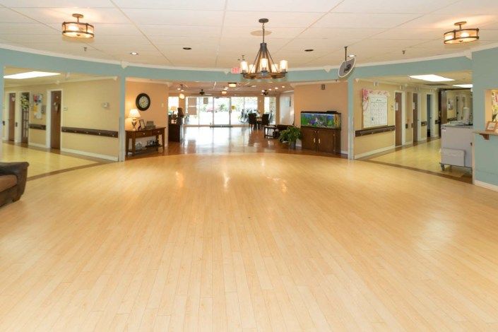 A spacious dance room with hardwood floors and elegant chandeliers.