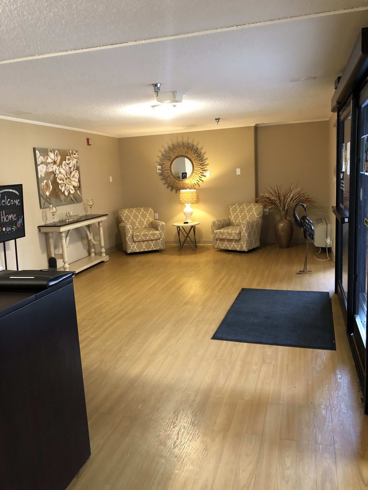 A cozy lobby area with chairs, a mirror, and artwork on the walls.