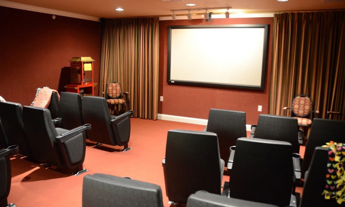 A cozy home theater setup with a large projector screen and comfortable seating.