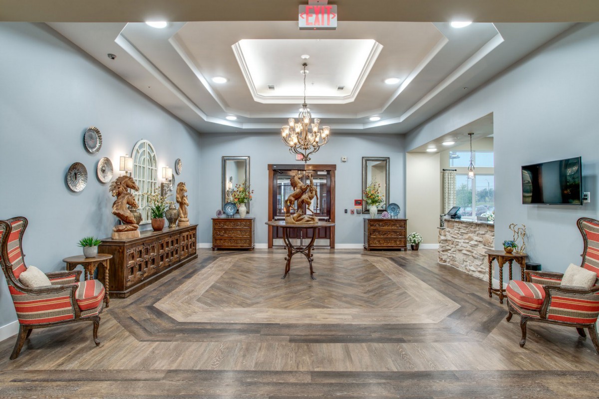 A beautifully decorated lobby featuring elegant furniture, a chandelier, and intricate flooring.