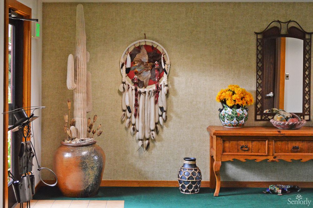 A cozy room with a dreamcatcher, vases, and flowers.
