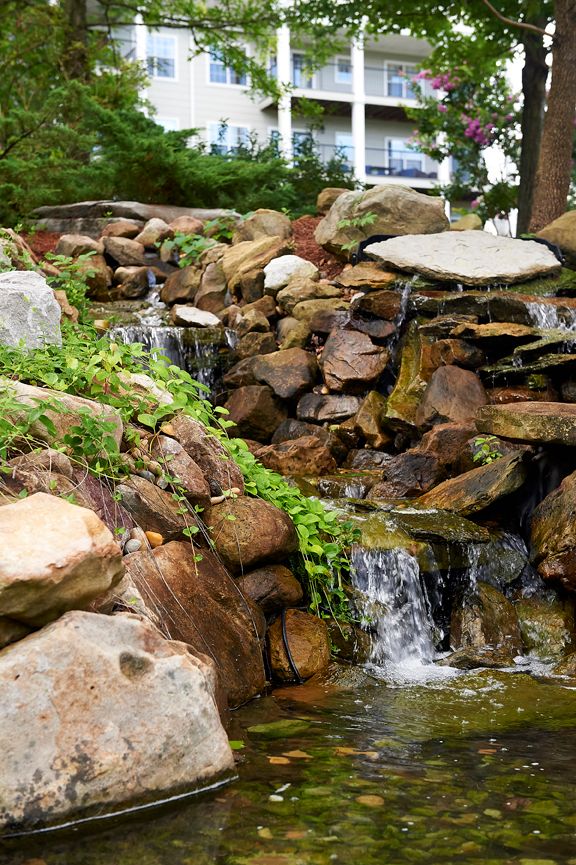 A small waterfall cascading over rocks surrounded by lush greenery.