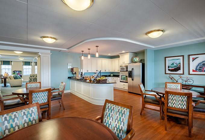 A modern open-concept kitchen and dining area with wooden flooring and elegant lighting.