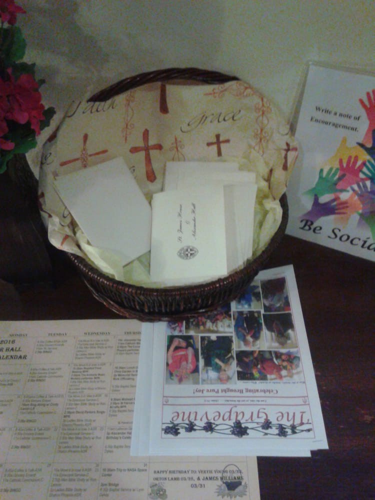 A display of church programs and brochures arranged in a basket on a table.