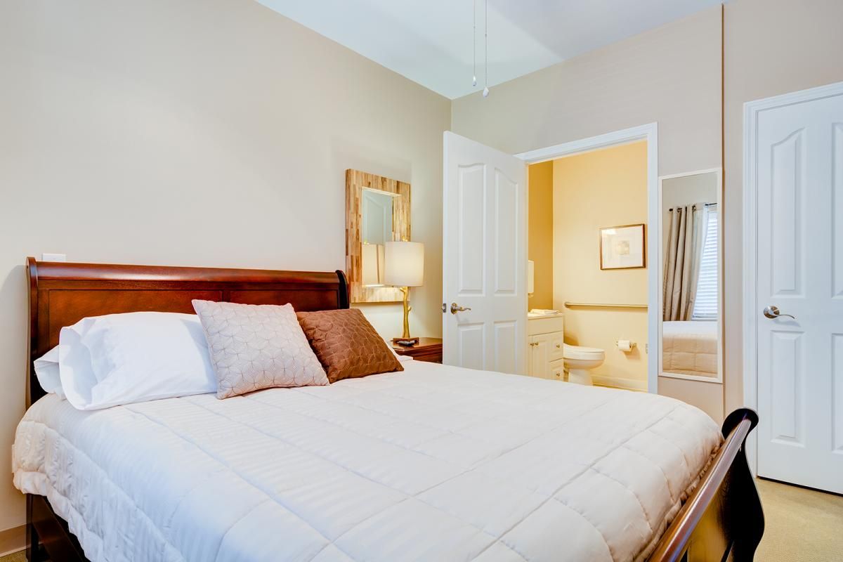 A cozy bedroom with a neatly made bed and adjoining bathroom.