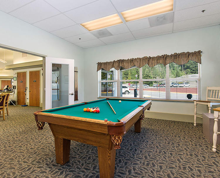 A cozy game room featuring a billiard table with balls and cue ready for play.