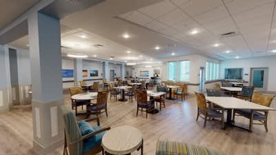A modern, spacious cafe interior with tables and chairs arranged neatly.