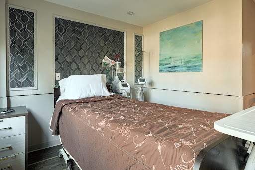 A well-appointed hospital patient room featuring a comfortable bed and medical equipment.