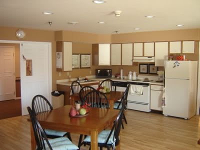 A cozy kitchen and dining area with wooden furniture and essential appliances.