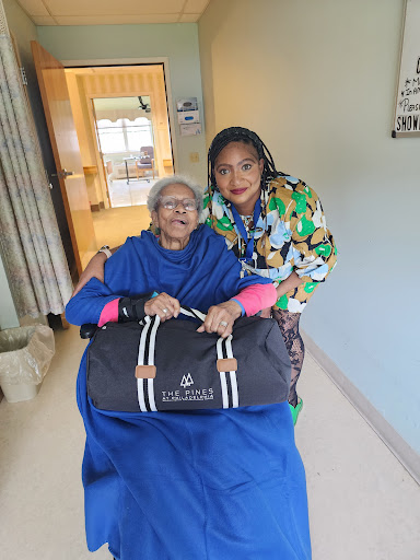 A joyful moment shared between a caregiver and an elderly woman as they prepare for a journey together.
