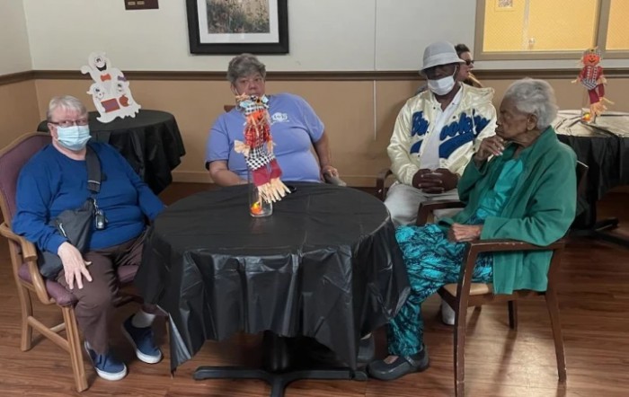 A group of seniors sitting together at a table in an indoor setting.