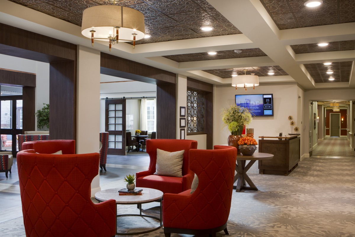 A modern lobby with comfortable red seating and elegant lighting.