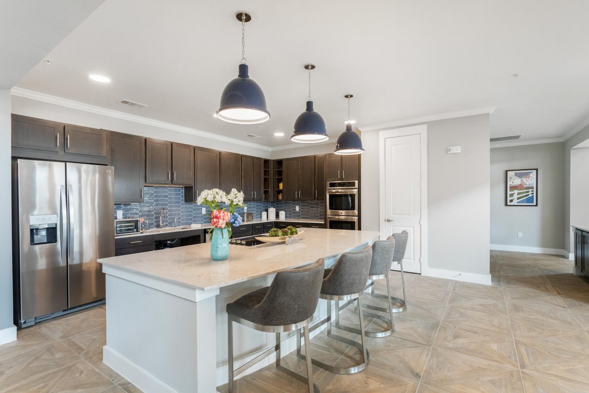 A spacious, modern kitchen with a large island and stylish pendant lights.