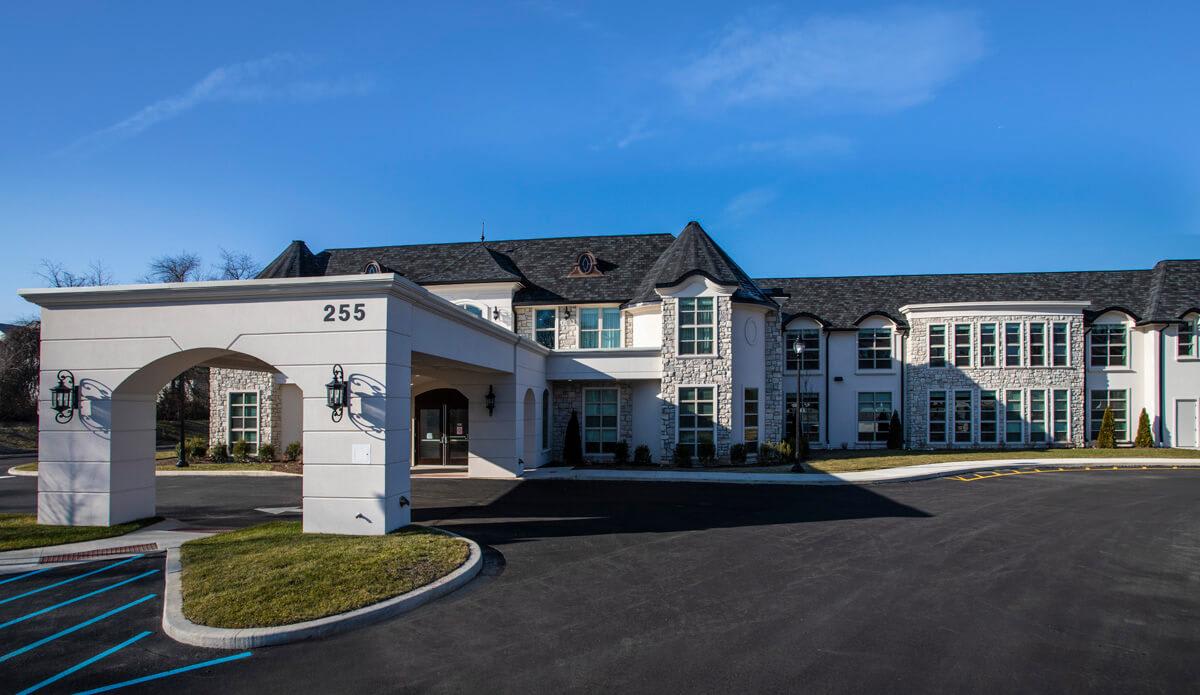 A modern two-story residential building with classic architectural features.