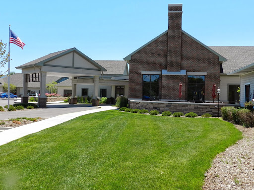 A well-maintained residential building with a manicured lawn and clear blue skies.