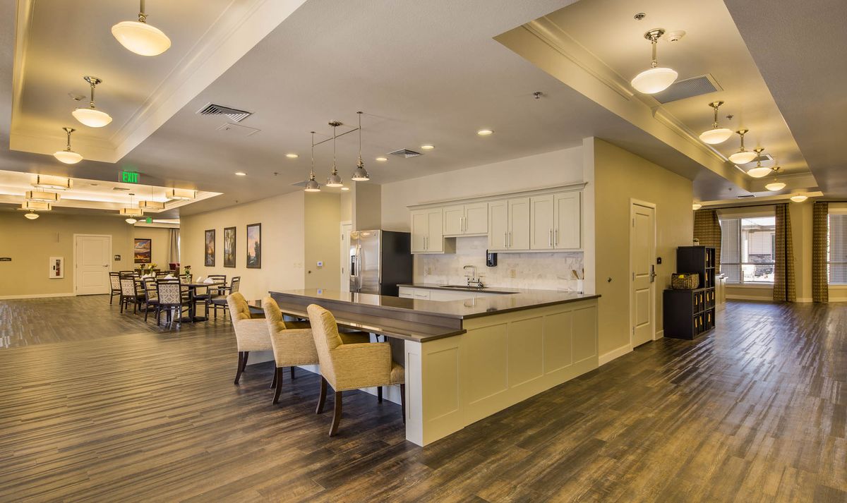 A modern kitchen with an open layout featuring a bar counter and dining area.