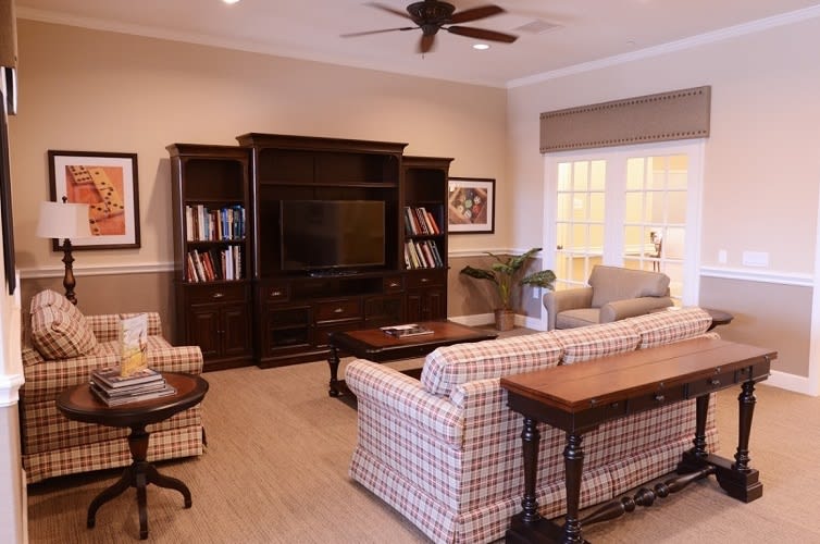 Cozy living room with a sofa, television, and bookshelf setup.