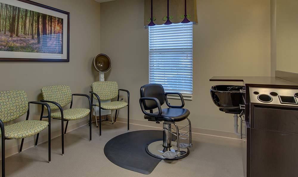 A cozy beauty salon waiting area with a hairdressing station and chairs.
