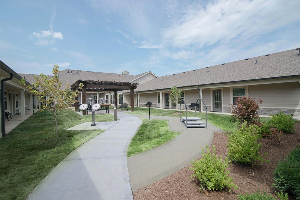 A peaceful courtyard with landscaped gardens and a pathway between buildings.