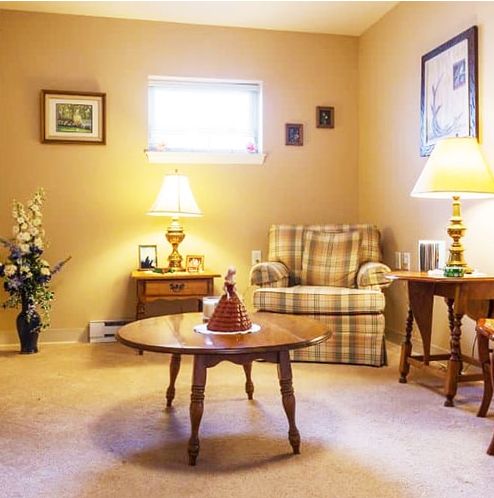 A cozy living room with comfortable seating, warm lighting, and a wooden coffee table.