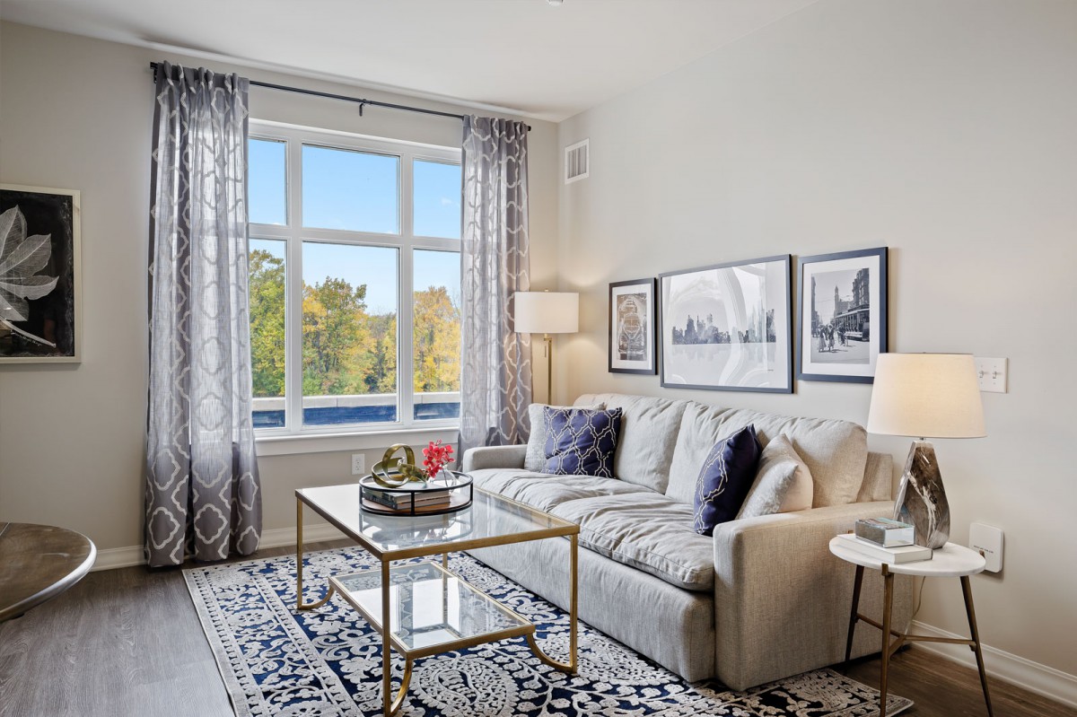 A beautifully decorated living room with a comfortable sofa, stylish coffee table, and large window providing natural light.
