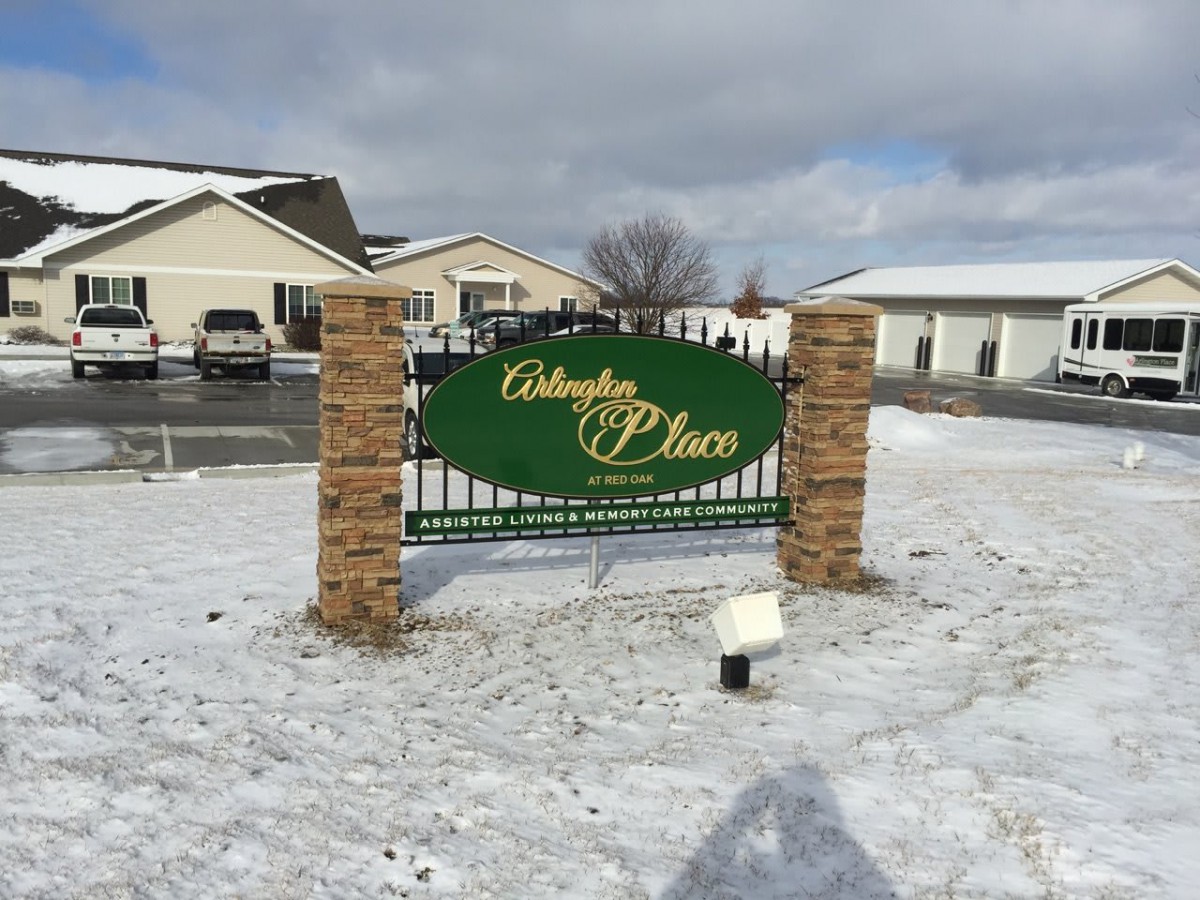 A sign for a real estate property stands amidst a snowy landscape.