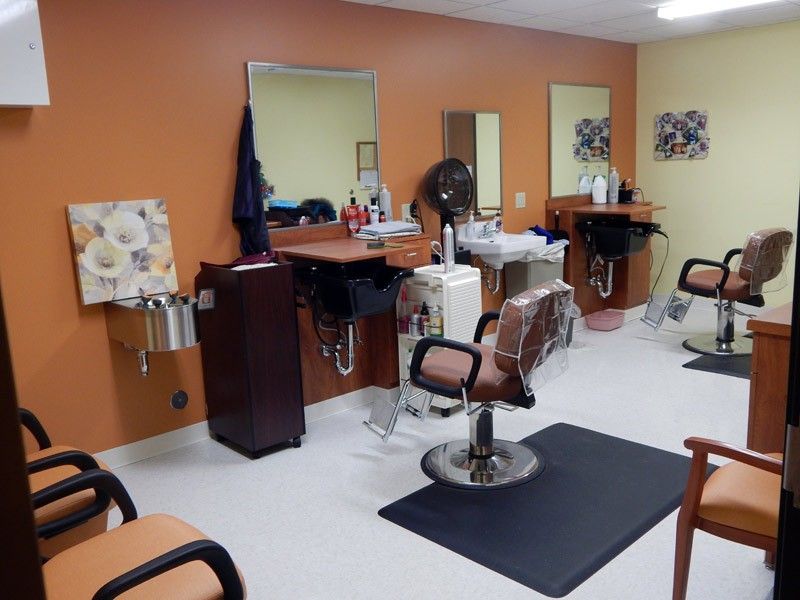 Interior view of a barbershop with chairs and mirrors.